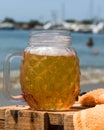 Vertical closeup shot of a decorative glass of fresh cold beer at a beach Royalty Free Stock Photo