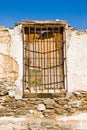 Vertical closeup shot of a destroyed old wall with closed window shutters Royalty Free Stock Photo