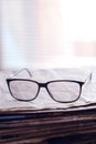 Vertical closeup shot of eyeglasses on the stack of newspapers - learning concept Royalty Free Stock Photo