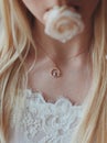 Vertical closeup shot of a female with a beautiful golden necklace holding a rose with her mouth Royalty Free Stock Photo