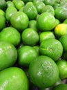 Vertical closeup shot of fresh Persian green limes at a market