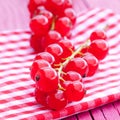 Vertical closeup shot of fresh pink peppercorns on a red napkin on a wooden surface Royalty Free Stock Photo