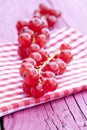 Vertical closeup shot of fresh pink peppercorns on a red napkin on a wooden surface Royalty Free Stock Photo
