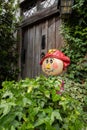 Vertical closeup shot of a garden scarecrow doll standing among green bushes Royalty Free Stock Photo