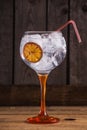 Vertical closeup shot of Gintonic with orange on a wooden table Royalty Free Stock Photo