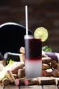 Vertical closeup shot of a glass of fresh vodka cranberry cocktail with a lime on a table with corks Royalty Free Stock Photo