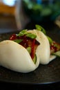 Vertical closeup shot of gourmet pork belly bao on a table Royalty Free Stock Photo