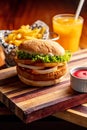 Vertical closeup shot of a gourmet thick burger on a wooden board