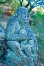 Vertical closeup shot of a granite sculpture in the shape of a mother monkey and its baby