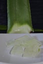 Vertical closeup shot of green aloe vera plant and a white plate with its crystals Royalty Free Stock Photo