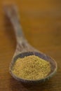 Vertical closeup shot of ground cumin in a wooden spoon Royalty Free Stock Photo