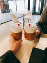 Vertical closeup shot of hands holding cups of takeaway coffee Royalty Free Stock Photo