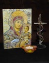 Vertical closeup shot of an icon, a Christian cross, and a candle