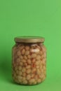Vertical closeup shot of a jar of dried beans on a green background Royalty Free Stock Photo