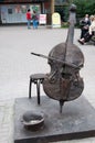 Vertical closeup shot of a metallic sculpture of a cello, a hat, and a chair in Irkutsk, Russia