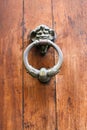 Vertical closeup shot of an old door knocker on a wooden door in Italy Royalty Free Stock Photo