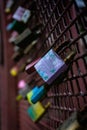 Vertical closeup shot of old love locks on a rusty fence