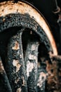 Vertical closeup shot of an old rustic train wheel with its paint peeling