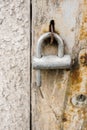 Vertical closeup shot of an old rusty lock hanging on a weathered door Royalty Free Stock Photo