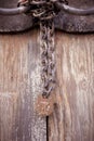 Vertical closeup shot of an old wooden gate with a rust iron lock and chains Royalty Free Stock Photo