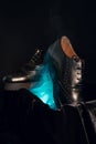 Vertical closeup shot of a pair of stylish black leather male shoes on a dark background