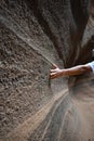 Vertical closeup shot of a person caressing canyon wall