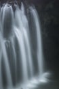 Vertical closeup shot of the pouring foamy cascades of a waterfall