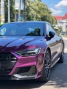 Vertical closeup shot of a purple Audi RS7 parked on a street