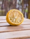 Vertical closeup shot of a rotten piece of lemon on a wooden surface