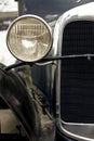 Vertical closeup shot of the round headlight of an old car