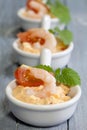Vertical closeup shot of salads with shrimp and tomato in small white bowls