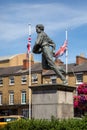 Vertical closeup shot of the sculpture of William Webb Ellis in front of a building on a sunny day