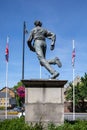 Vertical closeup shot of the sculpture of William Webb Ellis in front of a building on a sunny day