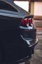 Vertical closeup shot of a shiny black luxurious car in the middle of a street Royalty Free Stock Photo