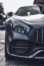 Vertical closeup shot of a shiny black luxurious car in the middle of a street Royalty Free Stock Photo