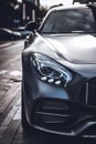 Vertical closeup shot of a shiny black luxurious car in the middle of a street Royalty Free Stock Photo