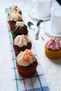 Vertical closeup shot of small cupcakes in a row on a folded kitchen towel Royalty Free Stock Photo