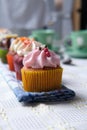 Vertical closeup shot of small cupcakes in a row on a folded kitchen towel Royalty Free Stock Photo