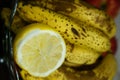 Vertical closeup shot of a squeezed fresh lemon and a bunch of bananas