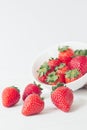 Vertical closeup shot of strawberries near a white bowl