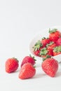 Vertical closeup shot of strawberries near a white bowl