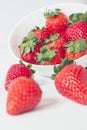 Vertical closeup shot of strawberries near a white bowl