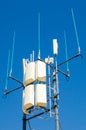 Vertical closeup shot of a telephone antenna on a clean blue background