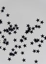 Vertical closeup shot of tiny black star stickers on the white background