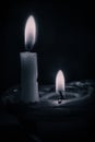 Vertical closeup shot of two burning candles with a black background Royalty Free Stock Photo