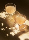 Vertical closeup shot of two glasses of juice in sun rays and shadows