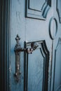 Vertical closeup shot of a vintage metal handle of a blue old door Royalty Free Stock Photo