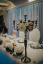 Vertical closeup shot of a wedding candelabra on a decorated table in the restaurant in Sarajevo Royalty Free Stock Photo