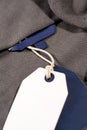 Vertical closeup shot of white blue tags on a string on a cloth with a blank blue tag on the neck