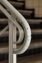 Vertical closeup shot of a white railing and the blurred stairs in the background Royalty Free Stock Photo